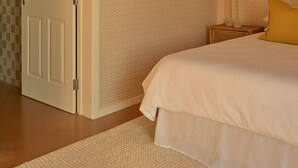 A bedroom with a bed, a nightstand, a lamp, and a door. - Lay Day House (Lorne)