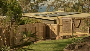 A solar panel roof, wooden fence, and a view of the sea. - Lay Day House - Vintage Beach Retreat (Lorne)