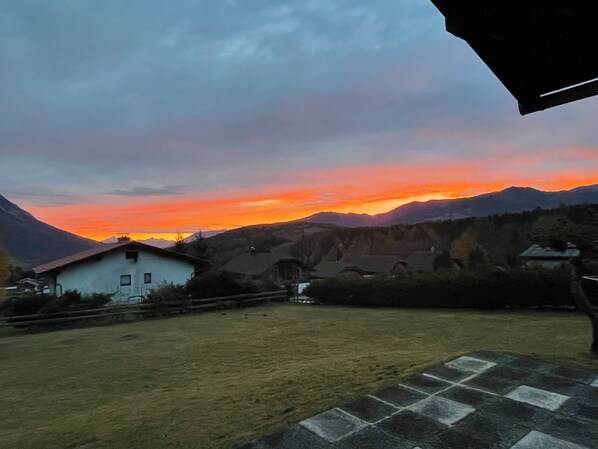 A rural landscape with a house, a grassy yard, and mountains in the background. - Cosy alpine house, Adults only (Mitterberg - St. Martin)