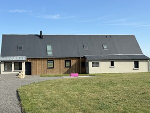 A modern two-story house with a sloped roof, large windows, and a wooden facade. - Gîte La Carelle in Vains at the foot of the Bay of Mont Saint Michel (Vains)