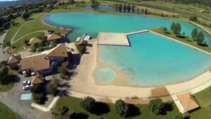 An aerial view of a residential area with a large swimming pool, houses, and surrounding greenery. - Château privé vacances & séminaires (Méreuil)