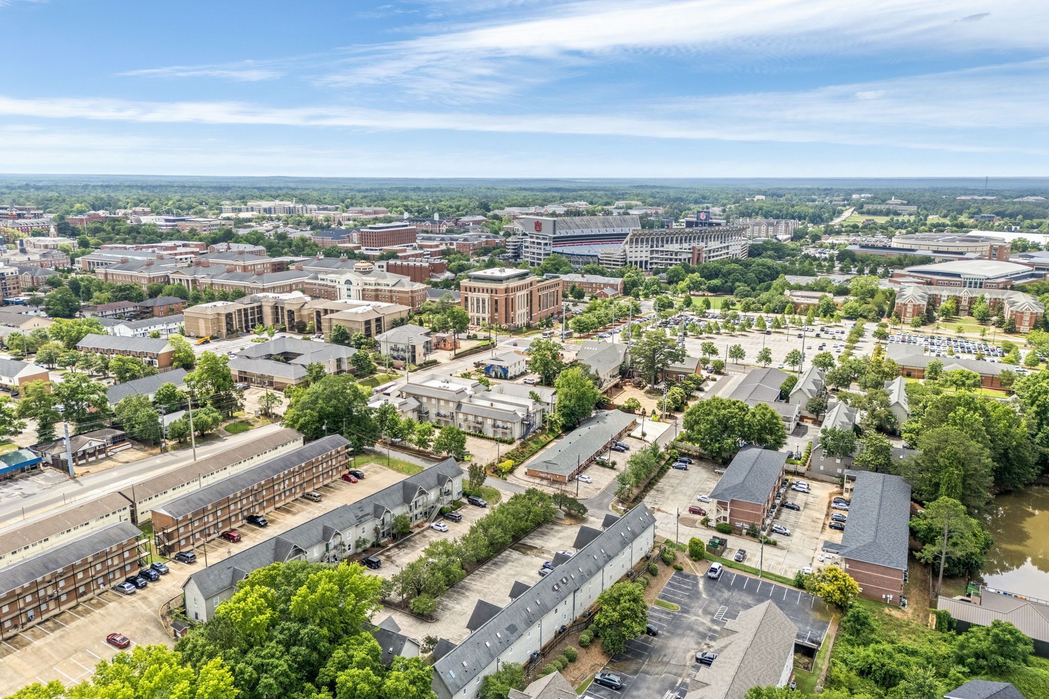 An aerial view of a campus with multiple buildings, parking areas, and green spaces.