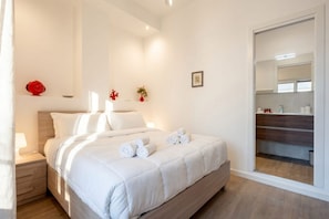 A bedroom with a bed, bedside table, and a mirror. - Lucia Italian Living (Bari)