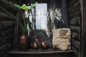 A shelf with a potted plant, ceramic chicken figurines, and a carved stone.