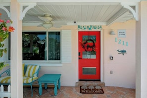 A red door with a 'Beach House' sign, a mailbox, and a 'Welcome' mat. - 3bd golf cart, pool, close to beach (Indian Rocks Beach)