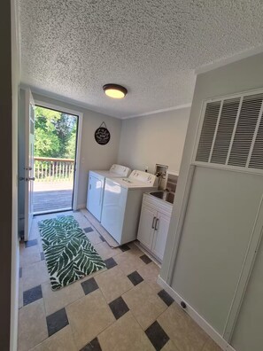 A laundry room with a washing machine, dryer, and a sink. - Lake Life Lodge At Smith Mountain Lake (Moneta)