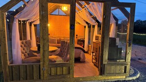 Ein gemütliches Holzhaus mit Bett, Sitzecke und einer kleinen Küchenzeile.