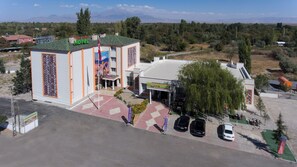 Un hotel con un diseño arquitectónico distintivo, un área de estacionamiento y vistas del paisaje circundante.