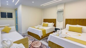 A hotel room with two beds, a mirror, an air conditioning unit, and a door. - Lavista Pyramid View (Giza)