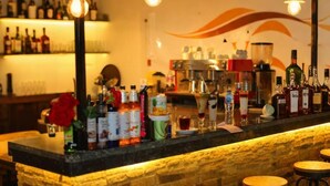 A bar area with a stone counter, stools, and various bottles and glasses. - Lavista Pyramid View (Giza)