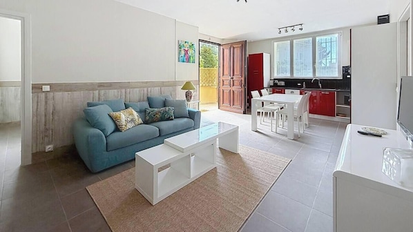 Un salon moderne avec un canapé, une table basse et un coin repas.