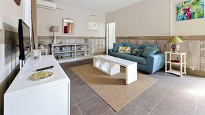 A modern living room with a sofa, coffee table, and a TV. - Apartment with terrace cap d'ail - near Monaco and Beaches (Cap-d`Ail)