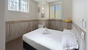 A bedroom with a bed, a bedside lamp, and a window. - Apartment with terrace cap d'ail - near Monaco and Beaches (Cap-d`Ail)