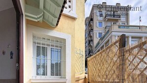 A balcony with a 'Welcome' mat, a window with metal bars, and a bamboo fence. - Apartment with terrace cap d'ail - near Monaco and Beaches (Cap-d`Ail)
