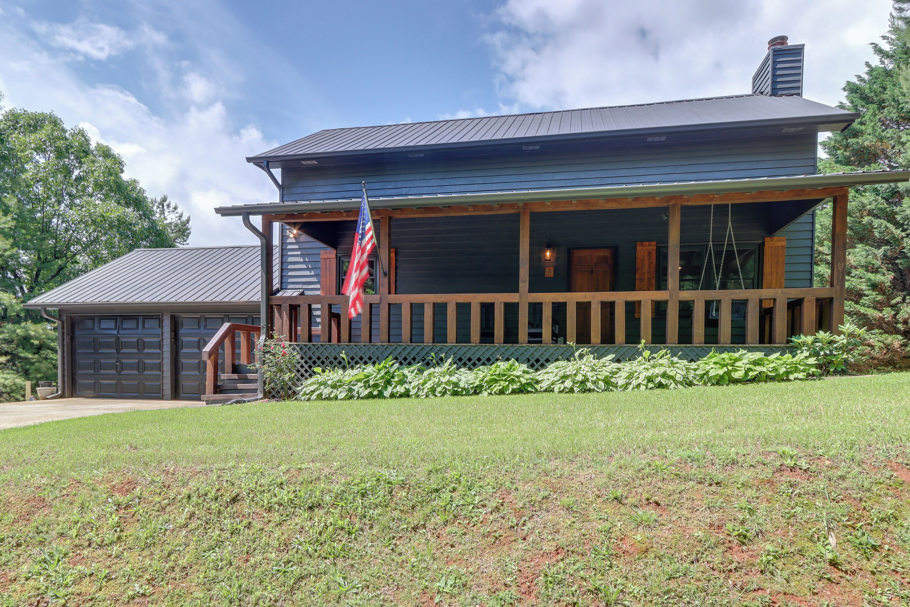A two-story house with a porch, a garage, and a well-maintained lawn.