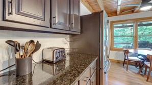 A kitchen with granite countertops, stainless steel appliances, and wooden cabinets.