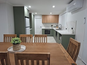 A modern kitchen with wooden cabinets, a built-in oven, and a white countertop.