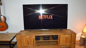 A wooden TV stand with a flat-screen TV displaying the Netflix logo. - Vacation home Albmatte-large garden-perfect for couples, groups and families (Sankt Blasien)