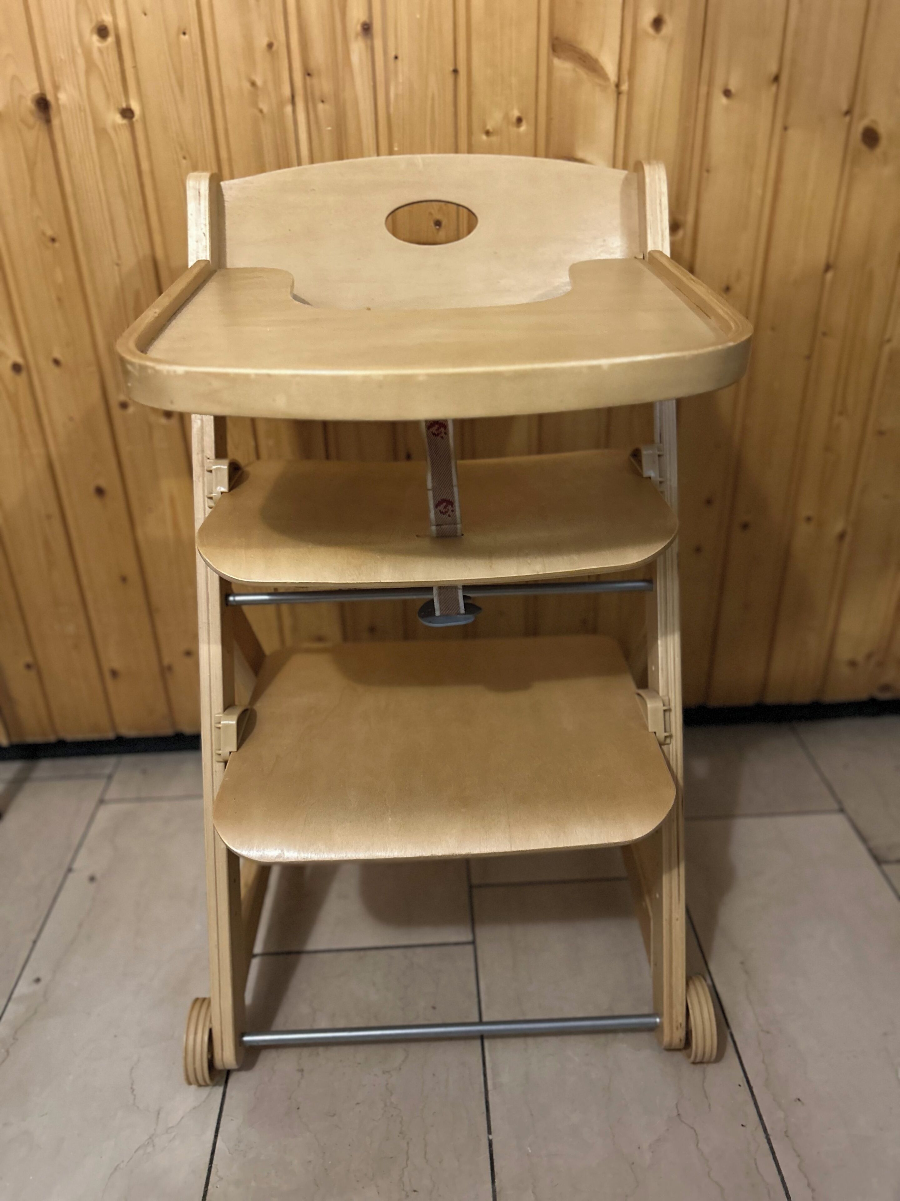 A wooden chair with a tray and shelves.
