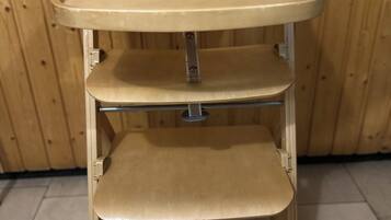 A wooden chair with a tray and shelves.