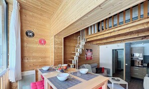 A wooden interior with a dining area, kitchen, and a view of the outside. - Duplex 8 pers - ski à pied (Isola 2000)