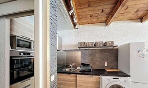 A compact kitchen with a built-in oven, a washing machine, and a refrigerator. - Duplex 8 pers - ski à pied (Isola 2000)