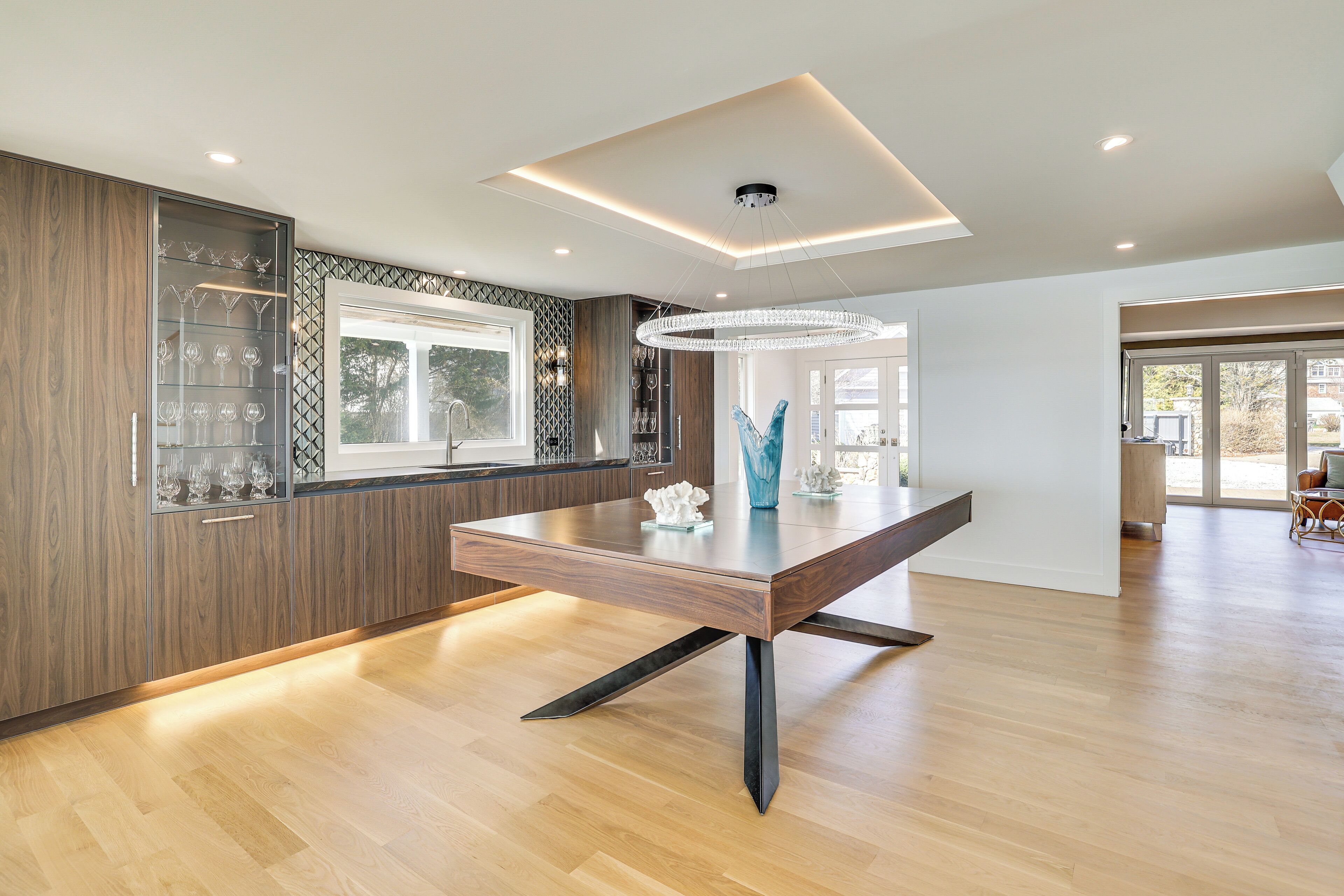 Een moderne keuken met een houten tafel, inbouwmeubels en een hanglamp.