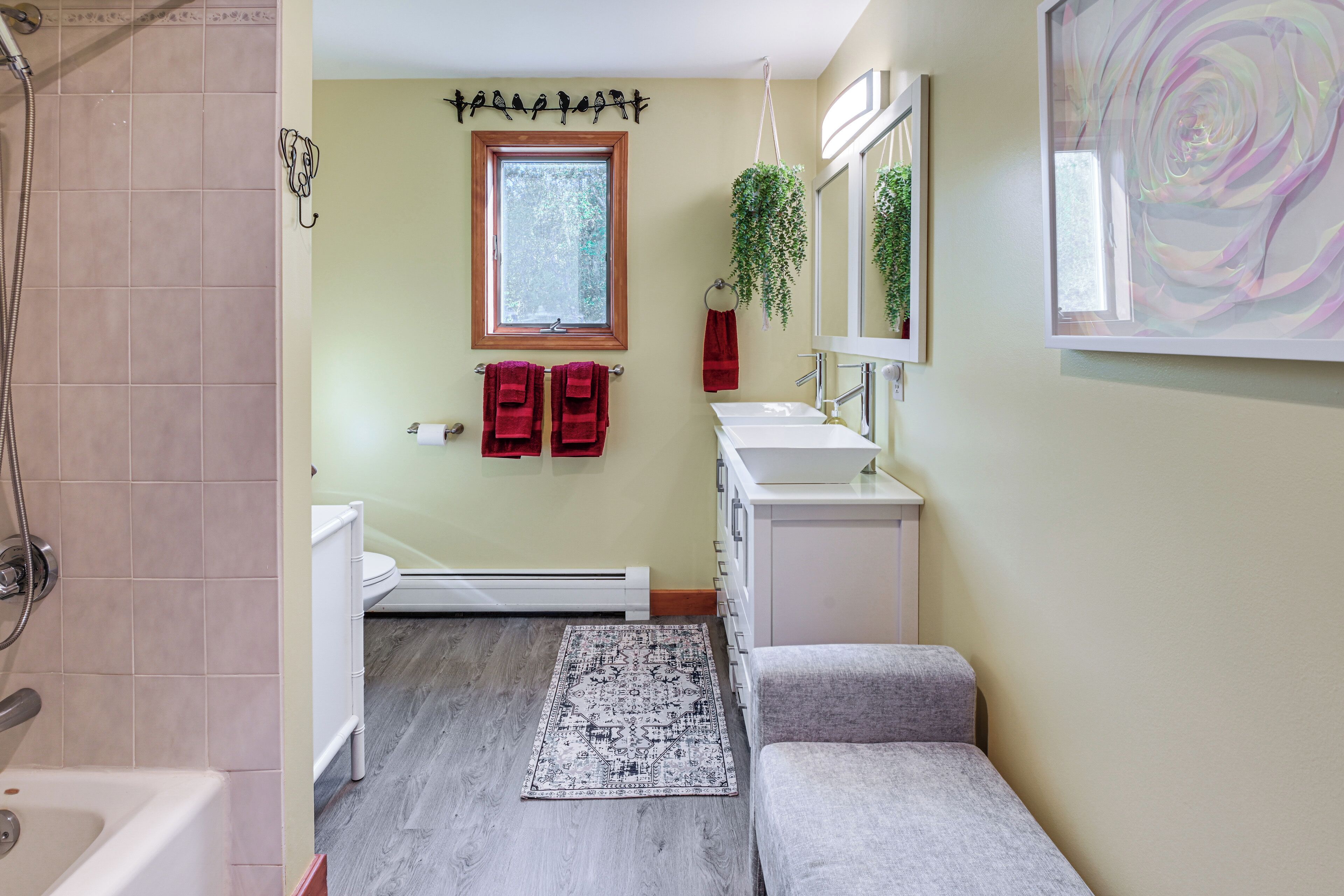 Un bagno con doccia, lavandino, WC, tappeto e porta asciugamani.