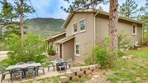 A two-story house with a patio area featuring a table and chairs. - 10 Mi to The Incline! Gem w/ Game Room & Fire Pit (Green Mountain Falls)