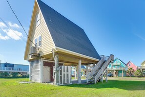 A single-story building with a sloped roof, a covered porch, and a staircase leading to a second level. - Walk to Waves! Surfside Beach House w/ Ocean View (Freeport)