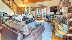 A spacious living area with a leather sectional sofa, a round coffee table, and a stone fireplace. - Private Hot Tub, Community Perks! Big Canoe Escape (Jasper)