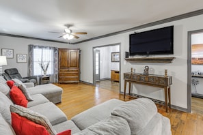 A living room with a grey sectional sofa, a ceiling fan, a flat-screen TV, and a wooden cabinet. - Pets Welcome! Comfortable and Spacious! Sleeps 6 (Frankston)
