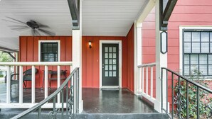 A red building with a black door, a covered porch, and a staircase leading to the entrance. - Pets Welcome! Comfortable and Spacious! Sleeps 6 (Frankston)