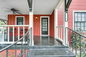 A red building with a black door, a covered porch, and a staircase leading to the entrance. - Pets Welcome! Comfortable and Spacious! Sleeps 6 (Frankston)