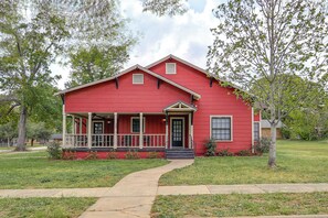 A red single-story house with a front porch, a small front yard, and a pathway leading to the entrance. - Pets Welcome! Comfortable and Spacious! Sleeps 6 (Frankston)