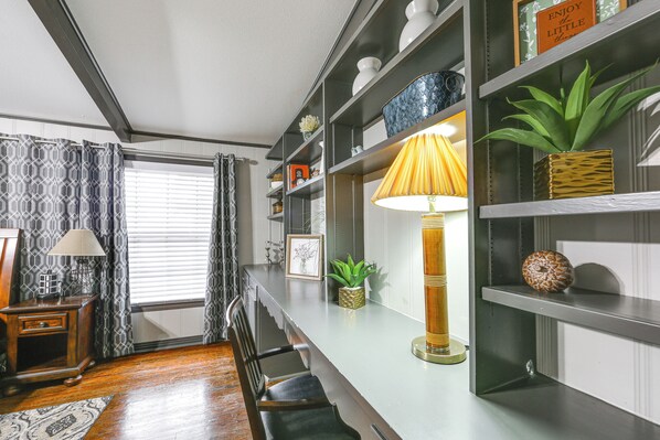 A modern living room with a wooden floor, a sofa, a coffee table, a lamp, and a bookshelf. - Pets Welcome! Comfortable and Spacious! Sleeps 6 (Frankston)