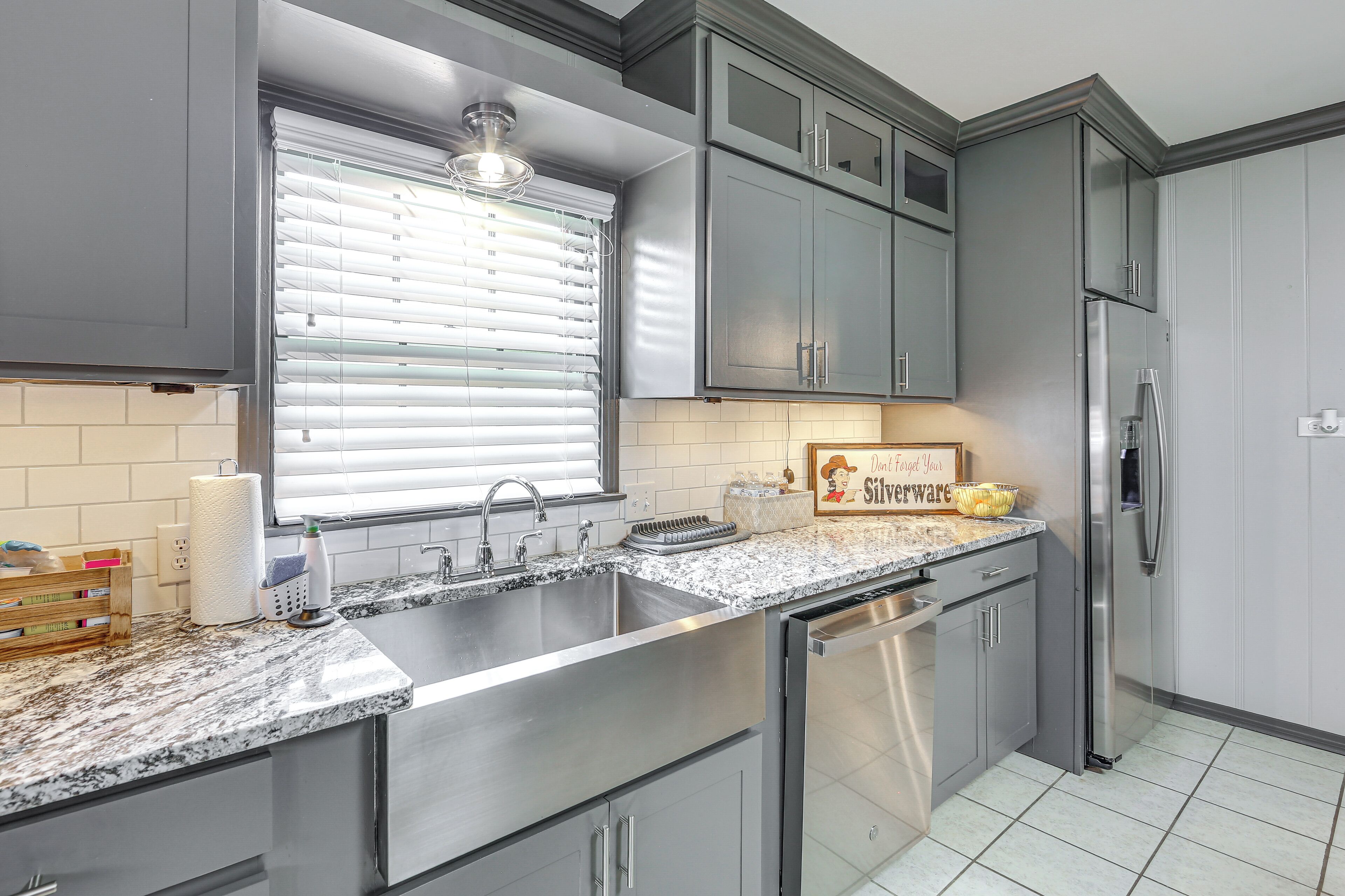 A kitchen with a stainless steel sink, a built-in dishwasher, and a refrigerator.
