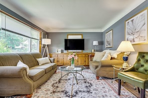 A living room with a sofa, armchair, coffee table, and a television. - Deck & Shared Yard! Relaxing South Saint Paul Home (South St. Paul)