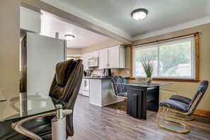 A modern kitchen with a glass dining table, two chairs, a refrigerator, and a microwave. - Deck & Shared Yard! Relaxing South Saint Paul Home (South St. Paul)