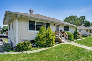 A single-story house with a front porch, a small front yard, and a visible garage. - Deck & Shared Yard! Relaxing South Saint Paul Home (South St. Paul)