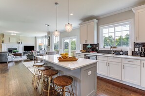 A spacious kitchen with a large island, bar stools, and a dining area with a fireplace.