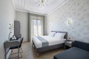 Una habitación de hotel moderna con cama, escritorio, silla y mesitas de noche.
