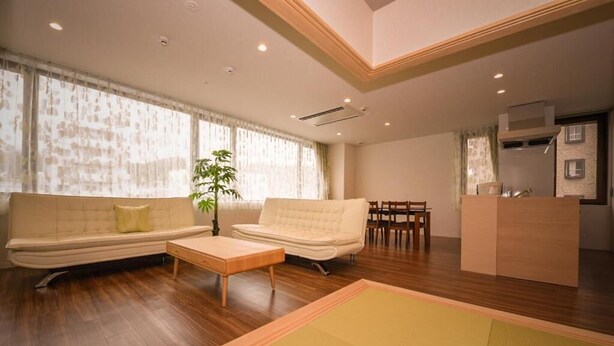 A modern living room with a sofa, coffee table, and a dining area. - Otaru Ryo An (Otaru City)