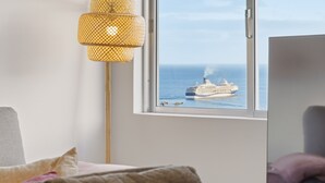 A room with a large window, a wicker lamp, a bed, and a television. - Little Paradise - Funchal (Funchal)