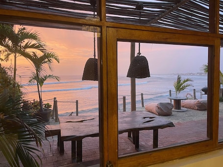 A beach view from a covered patio with tables and hanging lights.. w Beachview 4BR w Terrace in La Libertad