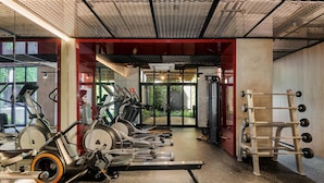 A gym with stationary bikes, treadmills, and a weight rack. - w Calm Cozy 1BR w Balcony in Tabacalera (Mexico City)