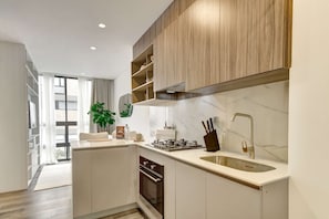 A modern kitchen with built-in appliances, a sink, and a window overlooking a cityscape. - w Luxury Cozy Loft in Chapinero (Bogotá)