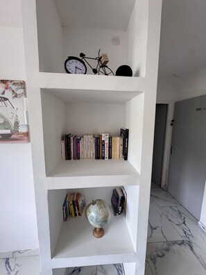 Ein weißes Regal mit Büchern, einem Fahrrad und einem Globus.