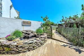 A pathway leading to a building with a sign reading 'THE PYRAMID.' - Direct Oceanfront Condo with Outdoor Pool - Amazing Beachfront location! Pyramid Building 7D (Ocean City)
