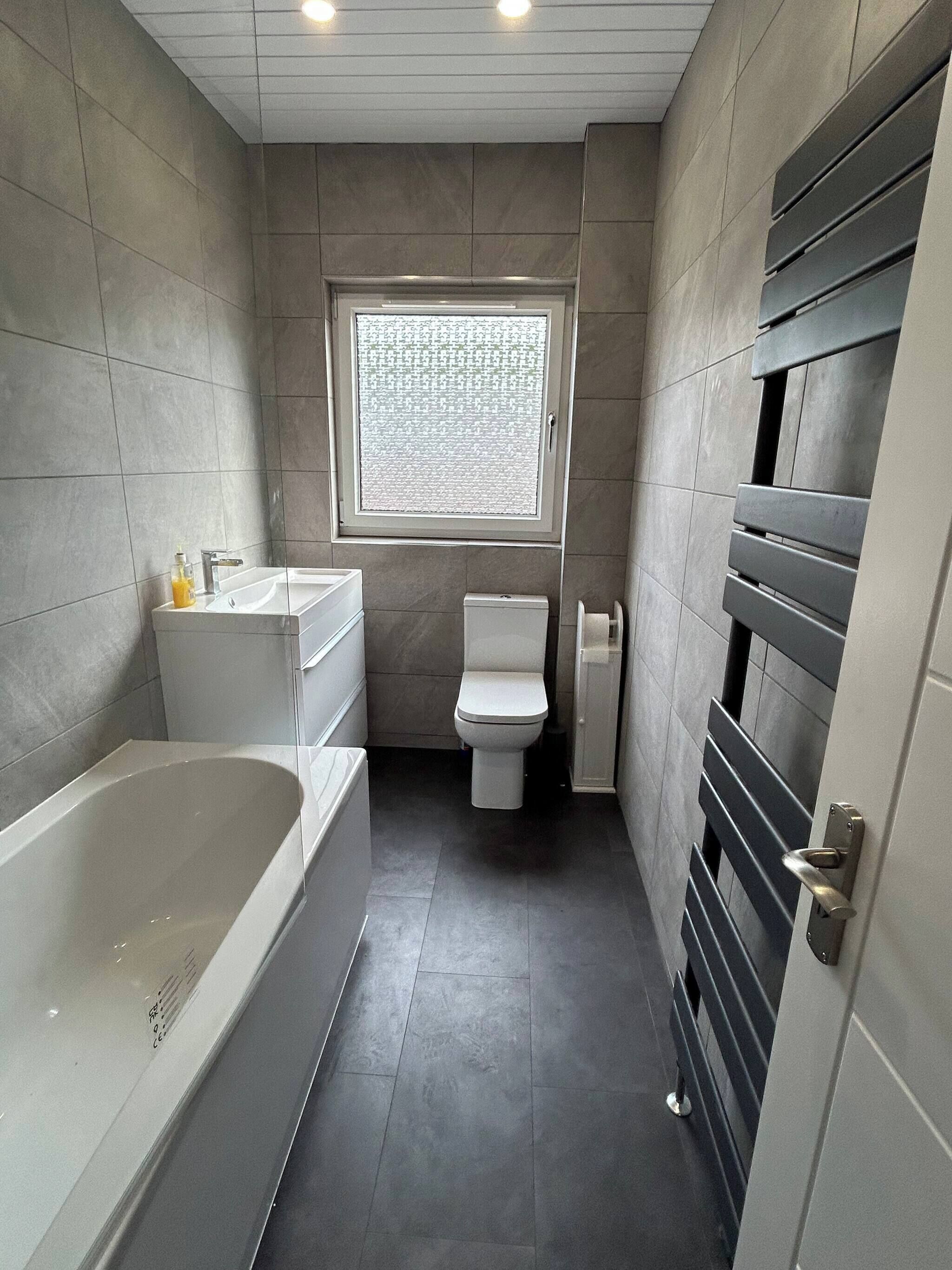 Un baño moderno con bañera, inodoro y ventana.
